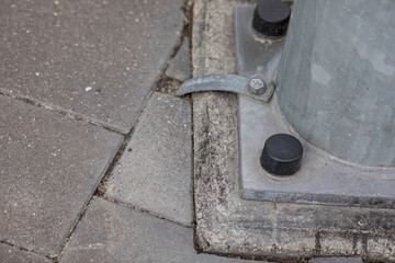 A metal lamp post attached to a concrete base.