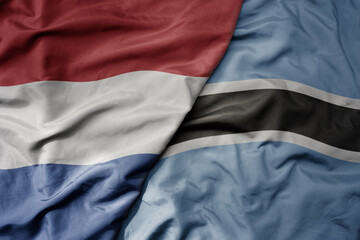 big waving national colorful flag of netherlands and national flag of botswana .