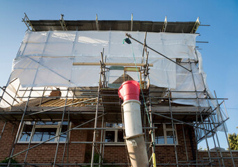 Europe, UK, England, Surrey, scaffolding tin hat on house roof renovation