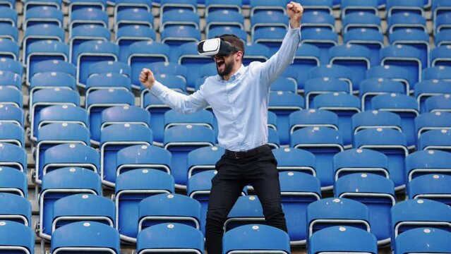 Businessman, sport fan wearing vr glasses, looking match on football stadium and winning. Successful game. Concept of sport, fan, betting and finances, gambling, bookmaker
