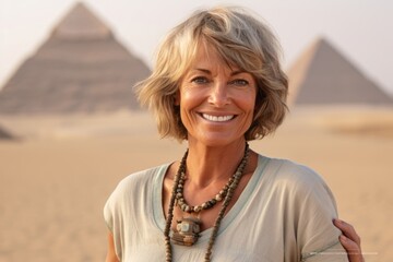 Photography in the style of pensive portraiture of a cheerful mature woman wearing a cute crop top in front of the pyramids of giza in cairo egypt. With generative AI technology - obrazy, fototapety, plakaty