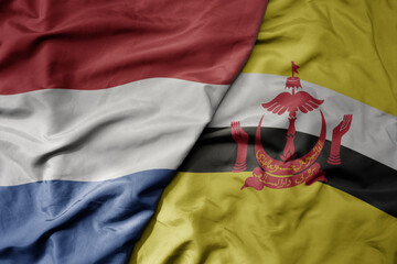 big waving national colorful flag of netherlands and national flag of brunei .