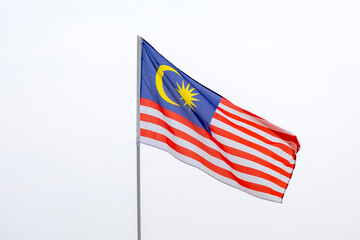 The Malaysia flag also known as Jalur Gemilang waves with a clear sky in the background. Independence Day or Merdeka Day celebration on 31 August and Hari Malaysia on 16 September, copy space concept.