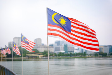 The Malaysia flag is also known as Jalur Gemilang waving with a city in the background....