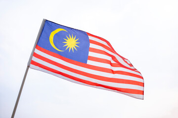 The Malaysia flag also known as Jalur Gemilang waves with a clear sky in the background. Independence Day or Merdeka Day celebration on 31 August and Hari Malaysia on 16 September, copy space concept.