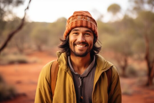 Close-up portrait photography of a happy boy in his 30s wearing a stylish beret near the uluru (ayers rock) in northern territory australia. With generative AI technology