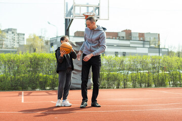 father and daughter playing basketball in the street