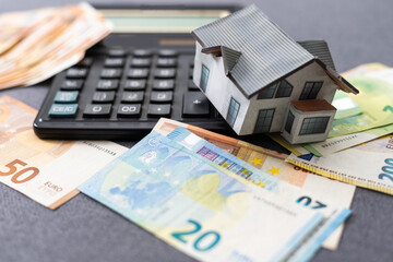 The concept of mortgage and rental housing and real estate. Mortgage credit lending. House of euro bills on the plan of the house and laid out dollar banknotes on a blue background