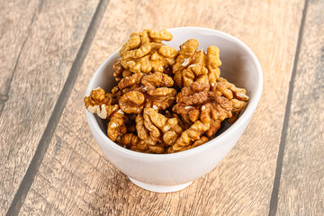 Cracked unshelled walnut in the bowl