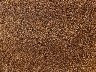 Abstract background with small stone chips, grainy texture. A simple pattern of small stones, sand. Detailed image of sand, stone plaster.