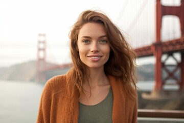 Close-up portrait photography of a satisfied girl in her 20s wearing a chic cardigan at the golden gate bridge in san francisco usa. With generative AI technology - obrazy, fototapety, plakaty