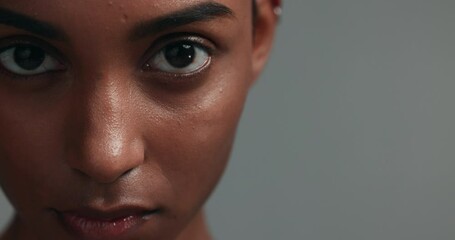 Intense, face and portrait of woman serious with natural skincare isolated in a studio grey background for beauty. Vision, eyes and closeup of confident young person with awareness for wellness