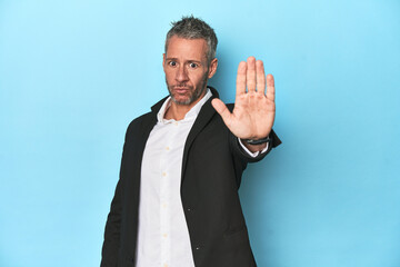 Caucasian businessman, middle-aged on blue background