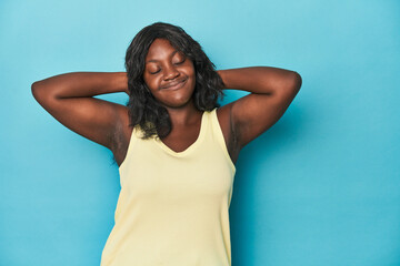 Young african american curvy woman feeling confident, with hands behind the head.