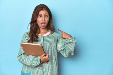 Young teacher holding notebooks, imparting knowledge pointing to the side