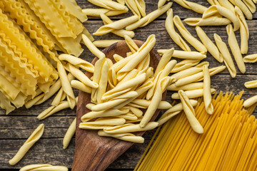 Fusilli pugliesi. Italian twisted pasta and spaghetti on wooden table. Top view.