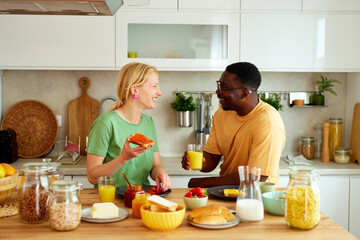 Multiracial couple enjoying breakfast together at home