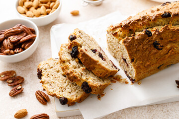 Fruitcake with cranberry, almond and pecan nuts sliced on a wooden board - obrazy, fototapety, plakaty
