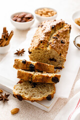 Fruitcake with cranberry, almond and pecan nuts sliced on a wooden board