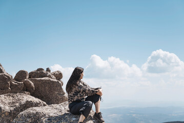 Woman sitting high in the  summer mountain with stunning view 