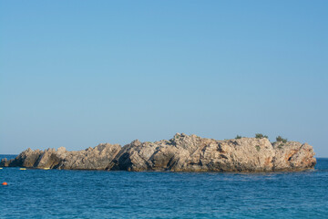 Fototapeta na wymiar A small lonely island in the blue sea