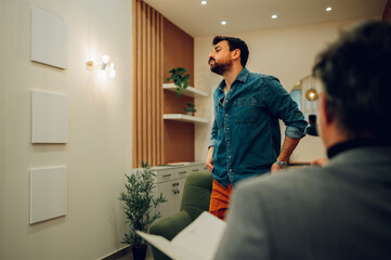 A sick and tired client is walking around the psychiatrist's office.
