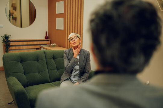 A senior female client is having an introjection while sitting in a doctor's office.