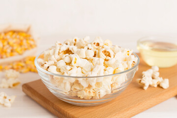 Prepared popcorn with ingredients on wooden table