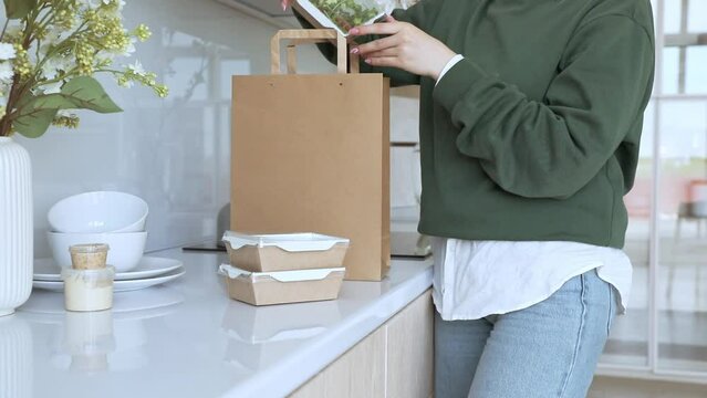 A young woman unpacks the good delivery of healthy good nutrition