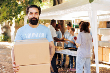 Compassionate man volunteering at a local food drive, offering non-perishable rations to the needy...