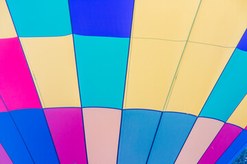 A particle view of a fully inflated hot air balloon with yellow, blue and pink squares.