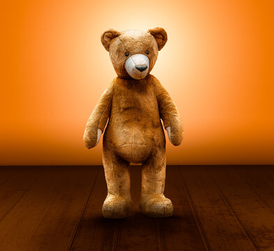 süsser teddybär steht vor einer orangenen wand und holzboden 
