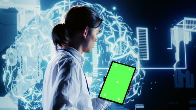 Tech savvy IT practitioner using green screen tablet to implement artificial intelligence parallel processing. Proactive inspector oversees chroma key device enabling AI to do machine learning