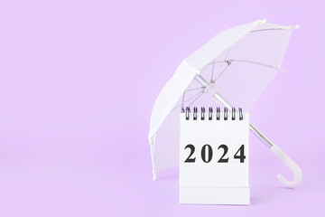 Calendar with figure 2024 and small umbrella on lilac background. Banner for design