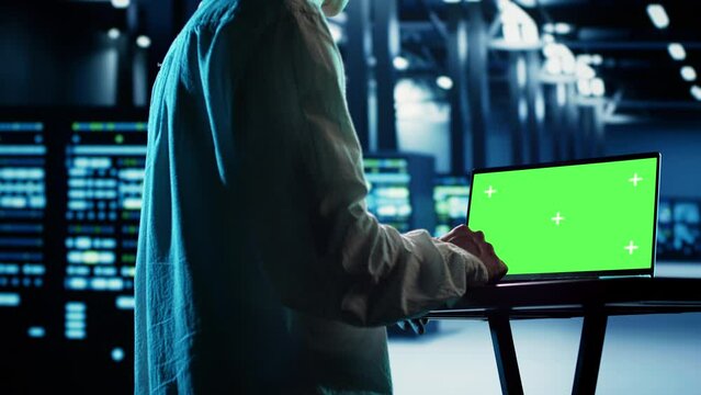 Asian employee using isolated screen laptop to implement artificial intelligence parallel processing. Professional works on chroma key device enabling AI systems to do machine learning inference