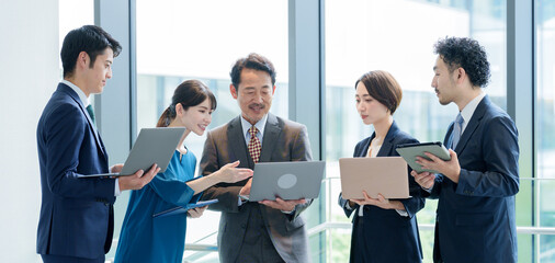 オフィスで立ってパソコンを使うビジネスパーソン