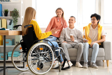 Group of teenage students with girl in wheelchair at school