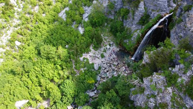 Aerial drone view of the waterfall in Theth national park, Albania. Passing over the waterfall in an overhead shot