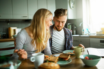 Young couple having breakfast in the kitchen
