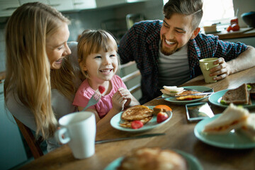 Young Caucasian family having breakfast in the kitchen
