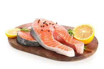 Wooden board with raw salmon steaks and different spices on white background