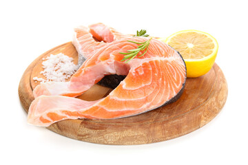 Wooden board with raw salmon steaks and different spices on white background