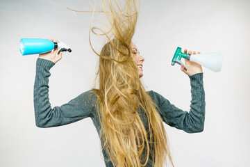Female messy long hair holds spray bottle