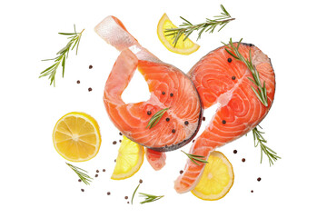 Flying raw salmon steaks and different spices on white background