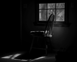Monochrome image of chair in window light