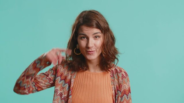 You are crazy, out of mind. Displeased woman pointing at camera, show stupid gesture finger near head, blaming some idiot for dumb insane plan idea, senseless talk. Girl isolated on blue background