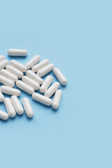 Medicine capsules on blue background.