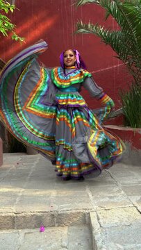 Young Mexican woman in a traditional folklore dress of many colors, traditional dancer.	 China poblana