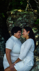 couple of lesbian women on the beach, dressed in white, lgbtqia+ representation, love between women