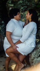 Naklejka premium couple of lesbian women on the beach, dressed in white, lgbtqia+ representation, love between women